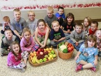 Students pose with baskets full of fruits and vegetables that are made possible by a federal FFVP grant
