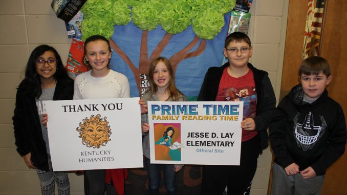 Students pose with posters announcing that Prime Time Reading is coming to Lay Elementary