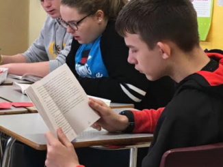 A close up of students reading the book "All of the Above".