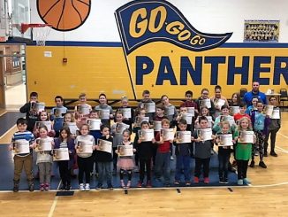 Students hold awards received during Central Elementary's Panther Way assembly on Friday, February 8.