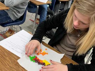 Student works on the ratio of Skittles during a math project at Lynn Camp Middle.
