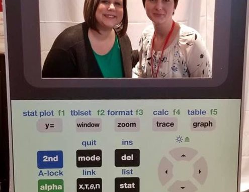 Fatemia Fuson and Rachel Wyatt pose for a photo in a calculator cut-out while at the T3 conference.