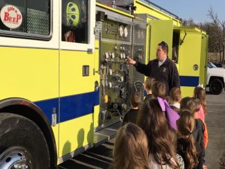 Students are shown lined up to see inside a fire truck at Lynn Camp Elementary.