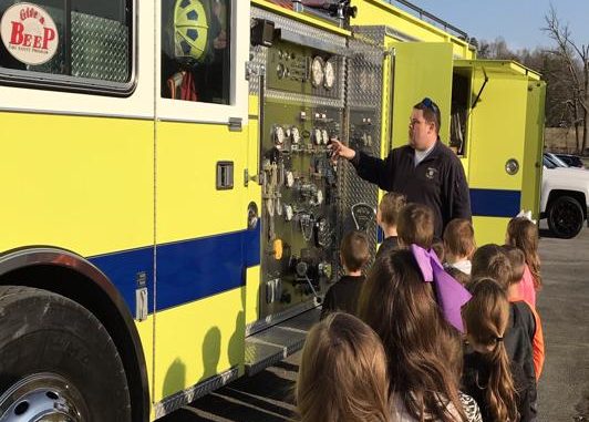 Students are shown lined up to see inside a fire truck at Lynn Camp Elementary.