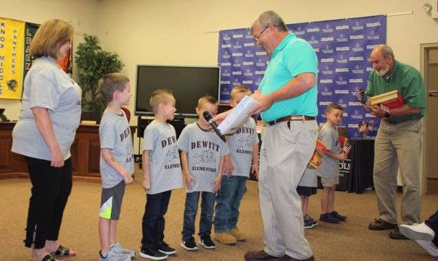 Board members Kevin Hinkle and Dr. Tom Ashburn are shown presenting certificates to Dewitt kindergarten students