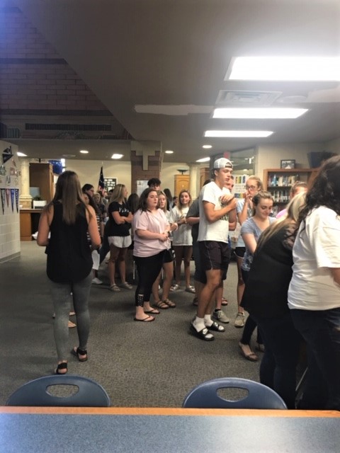 Link Crew leaders are shown in the library planning a group activity together.