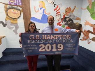 Gina Sears and Brian Frederick hold the G.R. High Attendance Banner