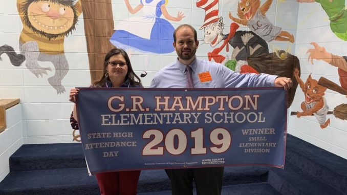 Gina Sears and Brian Frederick hold the G.R. High Attendance Banner