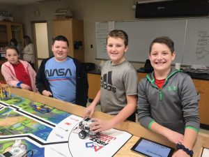 With smiles on their faces, these robot engineers paused testing their robot for a photo.