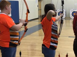 Two Lynn Camp archers are shown ready to shoot.
