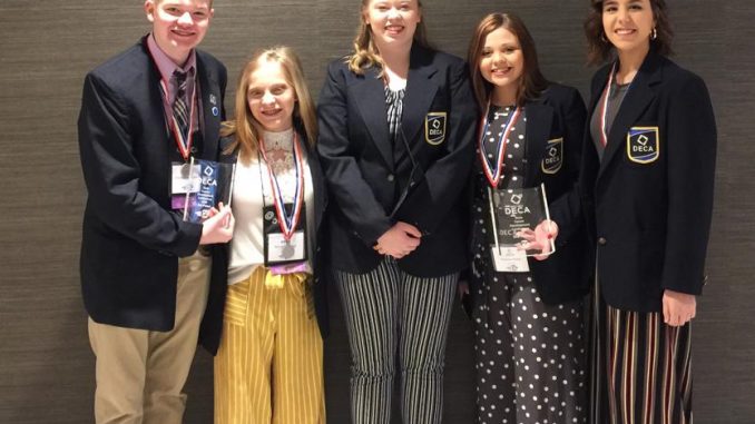 Five Lynn Camp students shown with medals after winning at DECA state competition.