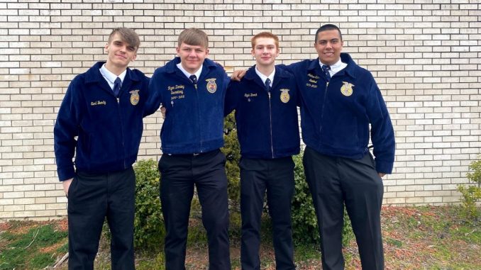 Four Lynn Camp FFA offers pose for a photo in their signature blue jackets.