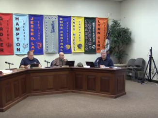 Members shown seated during December meeting with Superintendent video conferencing