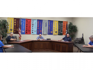 Board members are shown at the table calling the May 4 meeting to order.