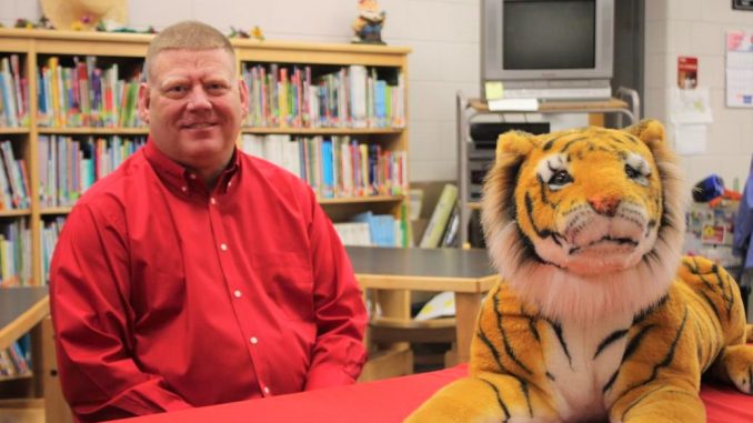 Clint Mays shown with a tiger in the library at Girdler Elementary
